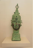 2001005 Koperen hoofd van een koningin uit Ife - Yoruba - Nigeria <b><i>Levensgroot bronzen hoofd van een Yoruba koningin uit Ife, Nigeria.</i></b> .<br><br>In het oude Benin-koninkrijk Ife, namen de Iyoba een belangrijke en historisch plaats in binnen de politieke hiërarchie van Benin. De titel werd voor het eerst verleend aan Idia, de moeder van koning Esigie, die haar politieke vaardigheden gebruikte om het koninkrijk van haar zoon te redden van ontbinding in de late vijftiende eeuw. Sinds die tijd worden koningin-moeders beschouwd als krachtige beschermers van hun zonen. Vanwege het enorme aanzien dat ze krijgen, hebben ze het recht om gegoten koperen sculpturen van zichzelf uit te geven voor religieus of persoonlijk gebruik. Dit prachtige bronzen hoofd dat hier wordt getoond, is een herdenkingsstuk van een koningin-moeder.<br><br>Het beeld bevat een hele reeks expressieve details en werd met de <b><i>“lost wax”</i> methode</b> in één stuk gegoten. Hierdoor is dit bronzen beeld uniek. De mal waarin ze gegoten worden, wordt immers stukgeslagen om hetbeelden eruit te kunnen halen. Deze figuur is geoxideerd en heeft een mooi verouderde patina. het dateert van ongeveer de helft van de 20e eeuw.<br><br>
<b>Maten in cm:</b> H 72 - B 22 - D 22.<br><br>
<b>Gewicht:</b> 8,1 kg.
 2001005-01.jpg