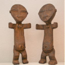 2001007 20ste eeuwse interpretatie van een "Akuaba" koppel - Kameroen <b>Mooie hedendaagse interpretatie van een<i>“Akuaba”</i> vruchtbaarheidskoppel - Kameroen.</b><br><i>(prijsaanduiding per stuk)</i><br><br><b>Afmetingen:</b> H 56 B 26 D 8. <br><br>Akuaba-figuren met schijfvormige kop zijn één van de meest bekende vormen uit de Afrikaanse kunst.<br>Deze beeldjes worden in verschillende contexten gebruikt:<br>In de eerste plaats door priesters tijdens ceremonies.<br>Anderzijds dragen ook vrouwen ze op hun lichaam. Ze hopen zo een kind verwekt te krijgen. <br><br>Het platte, schijfvormige hoofd is een sterk overdreven weergave van hun schoonheidsideaal: een hoog, ovaal voorhoofd, enigszins afgeplat door voorzichtige modellering van de zachte schedelbeenderen van de baby.<br>De afgeplatte vorm heeft ook een praktisch doel. Vrouwen dragen deze figuren gewikkeld in een doek tegen hun rug. Het doet denken aan de manier waarop ze in Afrika baby’s dragen.<br><br>De delicate mond is klein en laag op het gezicht gesitueerd en meestal rechthoekig of vierkant weergegeven.<br><br>Traditioneel hebben de meeste Akuaba abstracte, horizontale armen en een cilindrische torso met eenvoudige indicaties van de borsten en navel. De romp eindigt in een basis, in tegenstelling tot menselijke benen.<br><br>De stijl van deze beelden is zeer zeldzaam vanwege hun afwijkende vorm. Het is een geslaagde, vrije combinatie door een meester-houtsnijder van de “Akuaba” (Ashanti - Ghana) en “Pygmy” (Tikar - Kameroen) beeldstijlen. De overgrote meerderheid van houtsnijders beperken zich tot het kopiëren van gekende modellen. Het  is uitzonderlijk een nieuw werk te vinden.<br><br>De bovenzijde is voornamelijk Akuaba geïnspireerd, met horizontale armen die naar voor buigen. Het hoofd is niet meer volledig rond en overmaats, maar de ellipsvormige ogen en platte neus volgen nog de traditionele Akuaba stijl. Ook de afgeplatte achterzijde is uitgevoerd volgens traditionele zin. <br>De gebogen benen en uitgewerkte voeten liggen dan meer in lijn met de “Pygmy” stijl.<br><br>Figuren zoals deze worden gezien als een recente twintigste-eeuwse innovatie binnen de sculpturale traditie van de Akuaba. 
 2001007-01.jpg