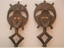 2001008 Bakota beeldjes -  hout bezet met gehamerde messing <b><i>Traditionele reliekbeschermer van de "(Ba)Kota" mensen (Mahongwe stam) uit Gabon.</i></b> .<br><br>Bang voor de doden, de Mahongwe vertonen grote devotie voor relieken van belangrijke voorouders. Bij het overlijden van een chef nemen de ingewijden verscheidene relieken van het lichaam van de overledene en bewaren die samen met andere magische elementen in geweven manden waarop ze deze beelden als bewakers plaatsen. Typisch voor deze houten beelden is de decoratie met dunne koperen of messing strips, plaatjes of draad. 2001008-01.jpg