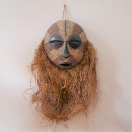 2015005 Luba "Kifwebe" Masker uit DRC <b>Maten: <br> Houten deel - H 44 - B 39 - D 17 cm.<br>Volledig masker - H 100 - B 65 - D 17 cm<br></b> <br><br> Een mooi uitgewerkt Afrikaans masker met een rond, lineair ingesneden gezicht en met goed bewaarde resten van witte en bruine kleiverf. <br>Grote goed bewaarde strooien baard.<br><br>Dit type komvormig masker met parallelle groeven werd gedragen samen met een raffiakostuum en gedanst in mannelijke / vrouwelijke paren die geesten vertegenwoordigden (kijwebe), die de wereld verbinden met de geestenwereld. Het werd gebruikt om belangrijke periodes van sociale transitie en transformatie te markeren.  2015005-01.jpg
